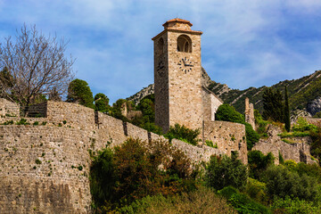 Old Bar, Montenegro. Striking view of the ancient clock tower and stone walls, vivid greenery and...