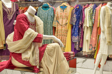 Sari displayed on mannequin at luxury shop with clothes in background, New Delhi