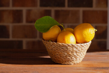 Home-grown lemons in a wicker basket illuminated by direct sunlight