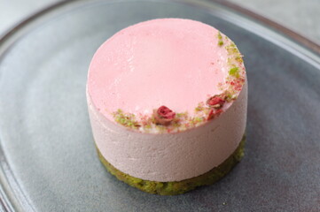 close up pink round cake on grey plate. top view