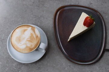 close up coffee and cheesecake on grey table. top view