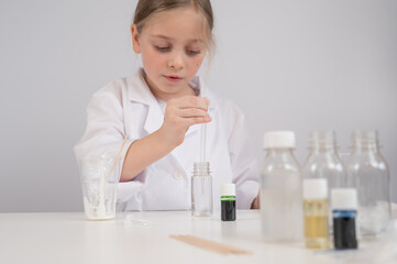 Caucasian girl doing chemical experiments on a white background. 