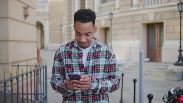 Portrait of a young African American man. Man is talking on the phone and rejoices at the positive call. The guy is happy that they called him and said that he was hired