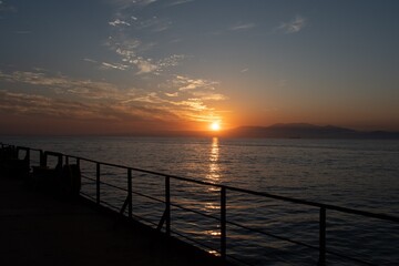 sunset view over the coastline from the deck of a cargo ship