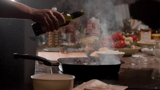 An experienced chef pours a bottle of wine into a hot frying pan, over a juicy, deeply-fried beef steak. The steam rises from the pan as the chef creates a symphony of flavors in a mesmerizing display