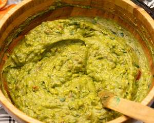 Fresh homemade guacamole in a wooden bowl. Party catering concept.
