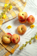 Several whole saturn peaches or flat peach on white wooden background..
