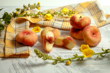 Halves and several whole saturn peaches or flat peach on white wooden background.. © kostik2photo