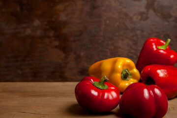 Assort of different shape and color bell pepper on wooden background..