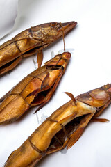 Smoked freshwater zander, pike and common bream fish for home use on white paper..