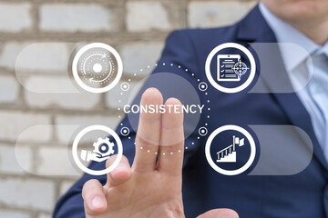 Business man using virtual touch interface sees word: CONSISTENCY. Consistency key to success,...