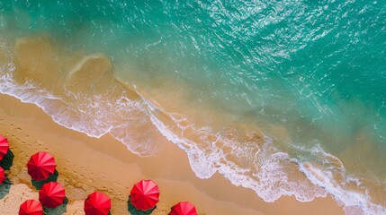 Fototapeta premium Red Umbrellas on the Beach: Aerial Photography Along the Sea