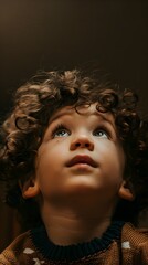 Little boy with curly hair looking up in a state of awe and curiosity