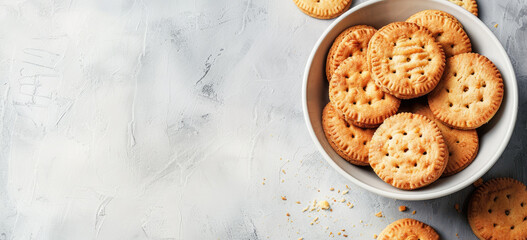 Bowl of round, golden-brown cookies with decorative patterns on textured surface