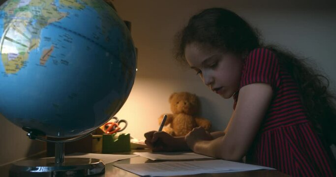 Child doing homework, child studying. Teenage girl wearing studying from home. Teen school student learning in home making notes, doing homework. 4K
