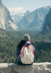 A hiker is sitting and  looking at wonderful scenic in Yosemite Valley the tunnel view, vertical...