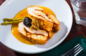 Delicious poultry dish - baked turkey breast with prunes, walnut and spicy sauce on plate