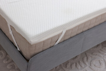 White memory foam mattress topper on grey bed
