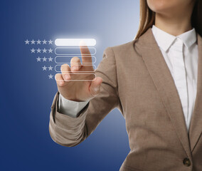 Woman choosing five stars on virtual screen against blue background, closeup. Customer satisfaction...