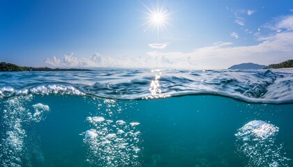 ocean water line splits sky and underwaer part air bubbles in deep blue bright sun light and blue clear sky