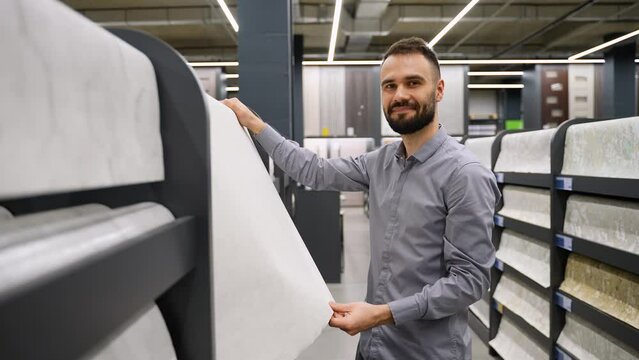 A man choose wallpaper in hardware store