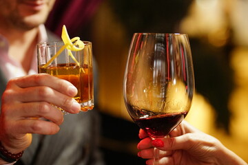 two glasses cheers, red wine and a cocktail