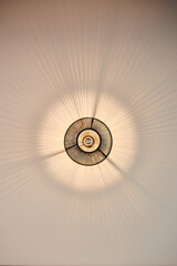 Circular light casting radial shadows on a plain surface