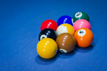 Close-up of 9 balls billiard pool on a blue table 