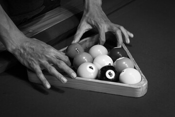 Male Hands setting balls for nine balls pool, black and white photo