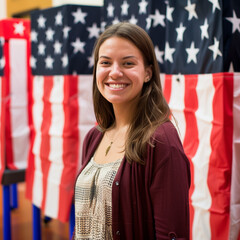 A smiling woman working at a voting center, votings booths behind her.