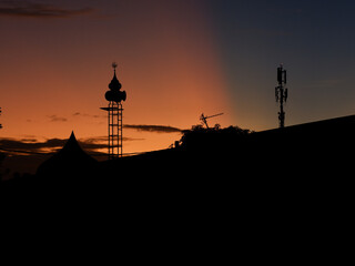 Obraz premium The silhouette of a mosque tower against the sunrise and blue sky