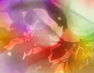 Hand shadow on colorful background with floral pattern, fabric texture. Multicolored sunlight...
