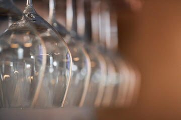 Hanging wine glasses in a row, blurred background