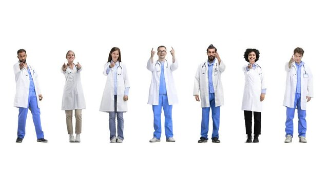 A group of doctors, in full height, on a white background, points forward