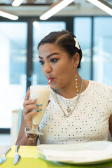 portrait of mexican woman drinking pina colada in a restaurant