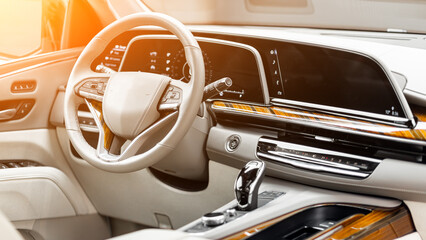 Interior of new modern car with steering wheel, shift lever and dashboard, climate control, speedometer, display.
