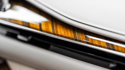 Close-up of a luxury car panel made of natural wood and leather
