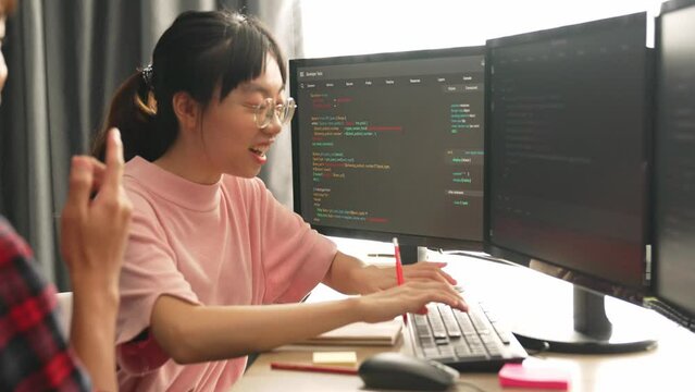 Slow motion back end software developer engineer for computer programming working together on debugging writing computing code, solving complex algorithms display on monitor in office. Burgeoning