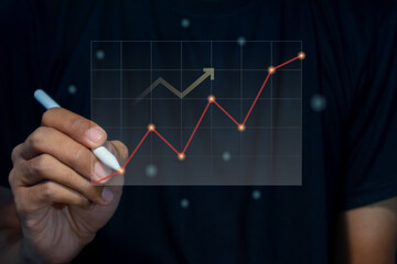 A man holding a pen with virtual screen of investment financial chart. Growth and successful...
