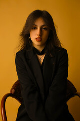 Portrait of a fashion model in the studio dressed in an elegant black jacket and trousers
