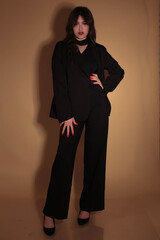 Portrait of a fashion model in the studio dressed in an elegant black jacket and trousers