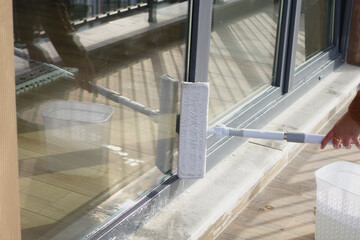 Rubber squeegee cleans a soaped window.