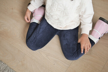  child sitting W posture on the floor .