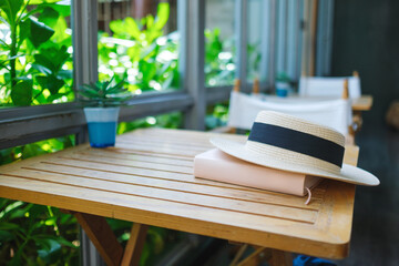 A hat and book on wooden table