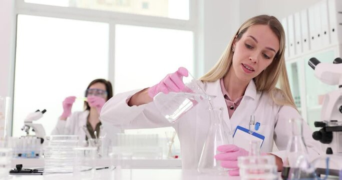 Women chemists in uniform work in modern laboratory
