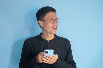 Young asian man showing happy face expression when holding mobile phone