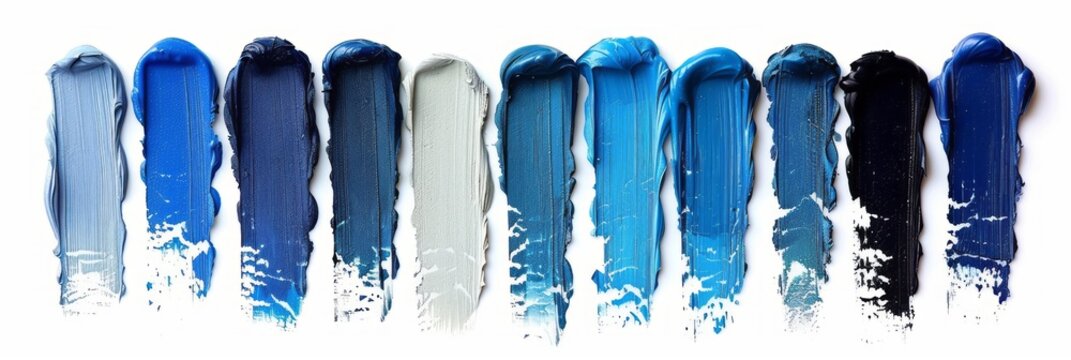 A set of blue color paint strokes isolated on a white background, viewed from the top, serving as blue shades swatches for makeup, cosmetic product, or beauty industry concept.