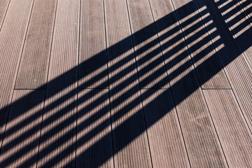 Sprite partition shadow seen over wooden deck on outdoor terrace