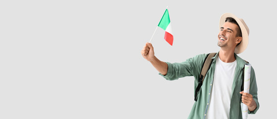 Male tourist with map and Italian flag on light background