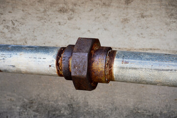 Rusty old metal pipe with valve and bolt
